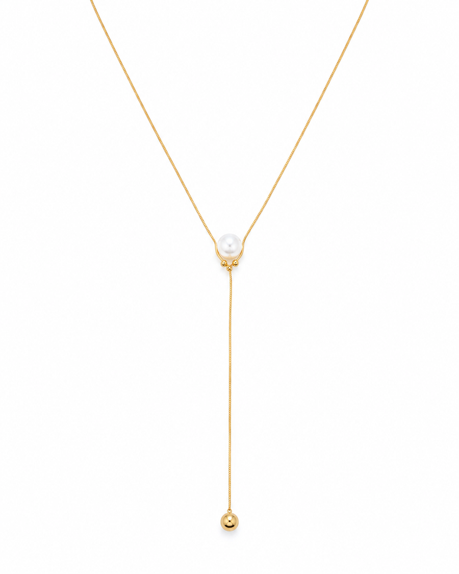 A delicate gold Y-necklace featuring a central white pearl and a long drop chain ending in a small gold bead, set against a plain white background.