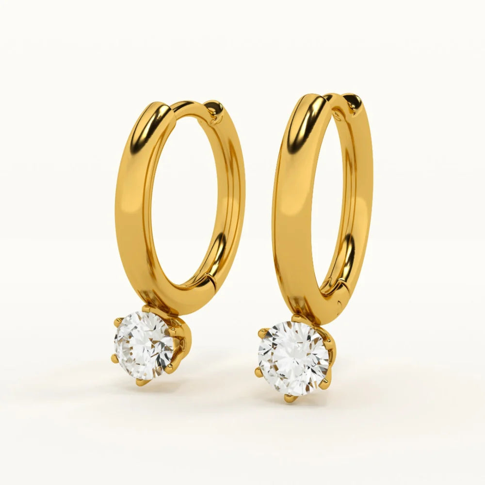 Gold hoop earrings with round gemstones on a white background