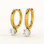 Gold hoop earrings with round gemstones on a white background